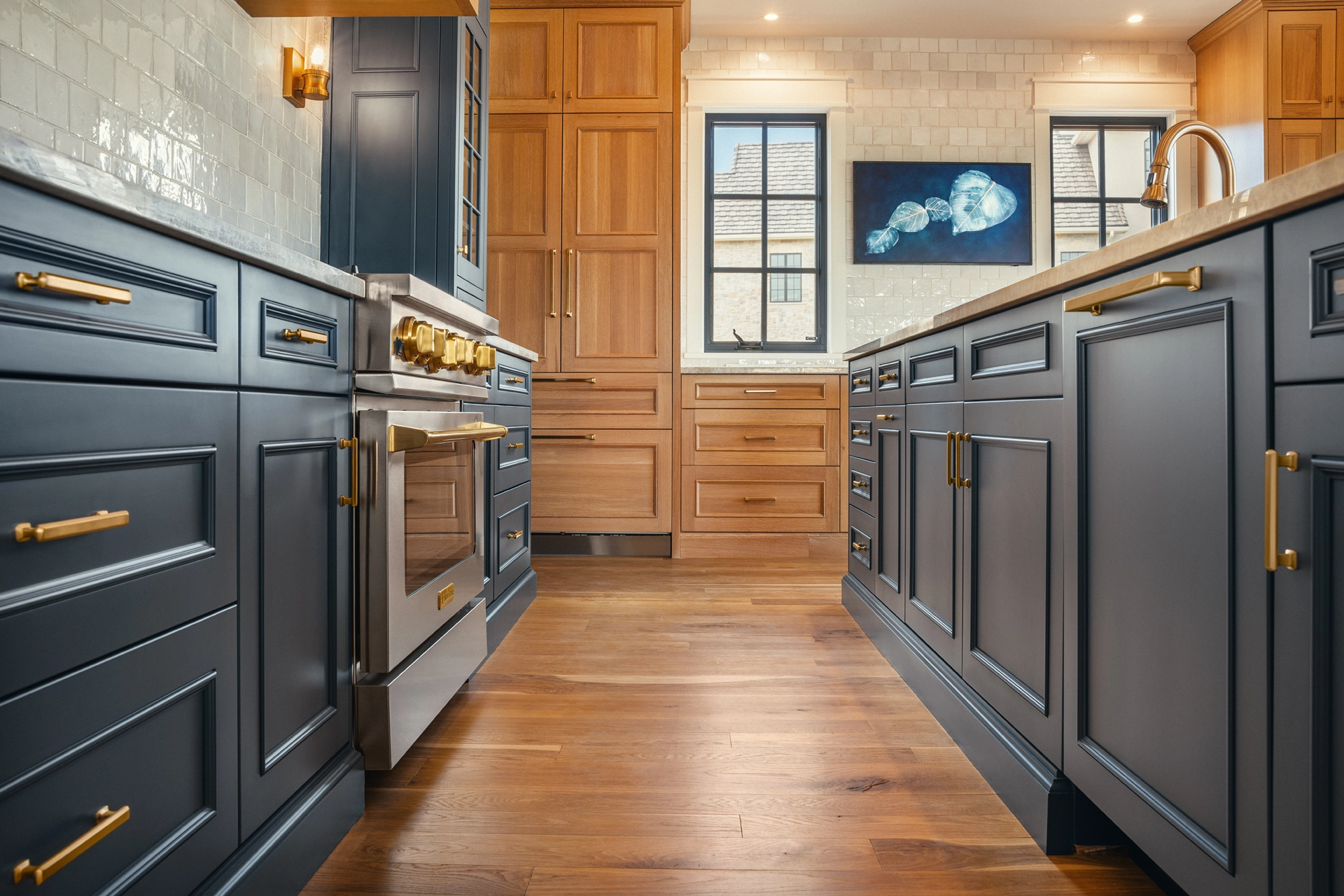 Beautifully remodeled kitchen with a large island featuring a sleek stove with maple blend cabinets in the Laramie door style, painted in the neutral shade of Prairie Dove.
