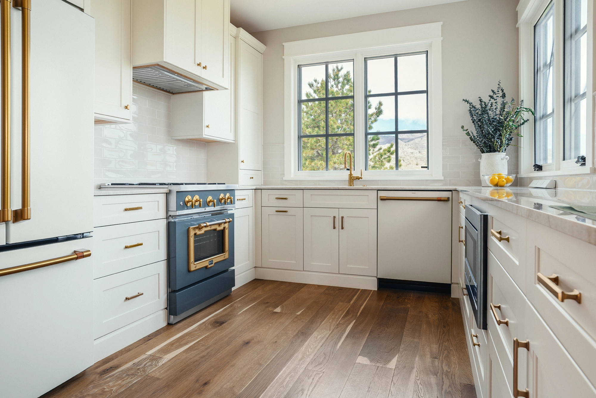 Beautifully remodeled kitchen with a large island featuring a sleek stove with maple blend cabinets in the Laramie door style, painted in the neutral shade of Prairie Dove.
