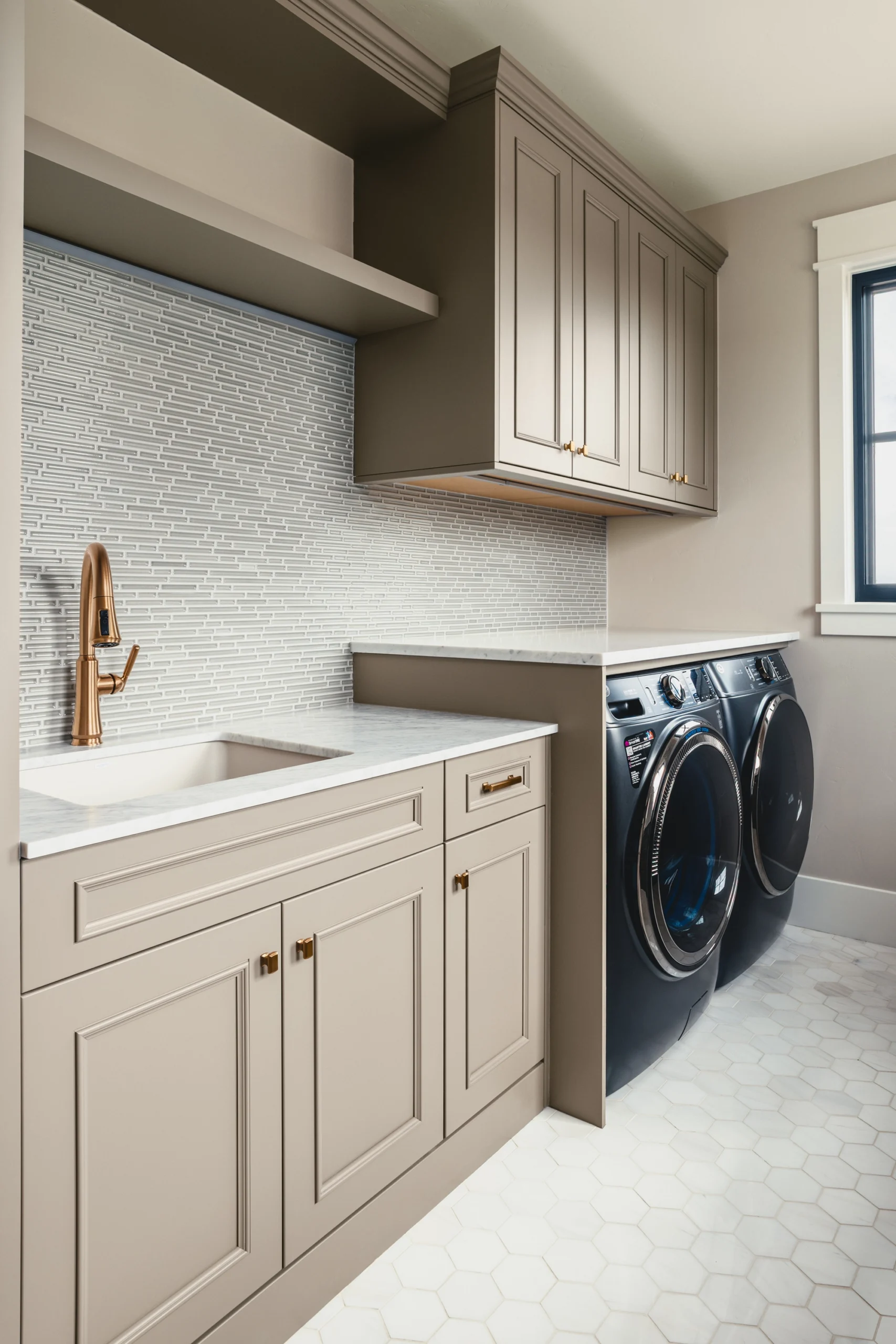 Beautifully remodeled kitchen with a large island featuring a sleek stove with maple blend cabinets in the Laramie door style, painted in the neutral shade of Prairie Dove.